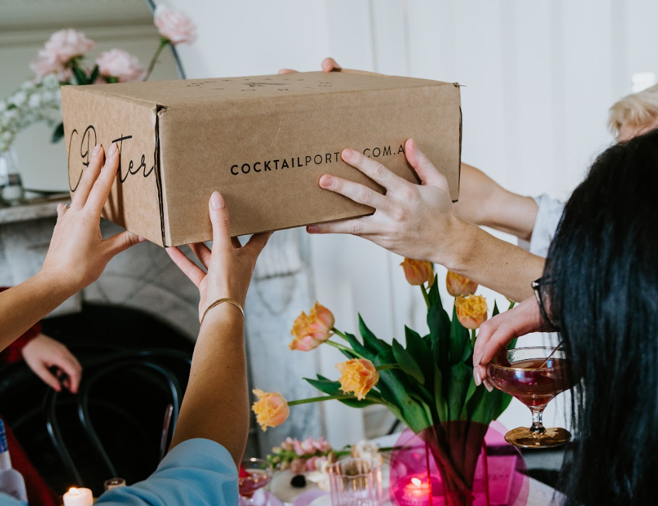 People holding a box of Cocktail Porter's Kit